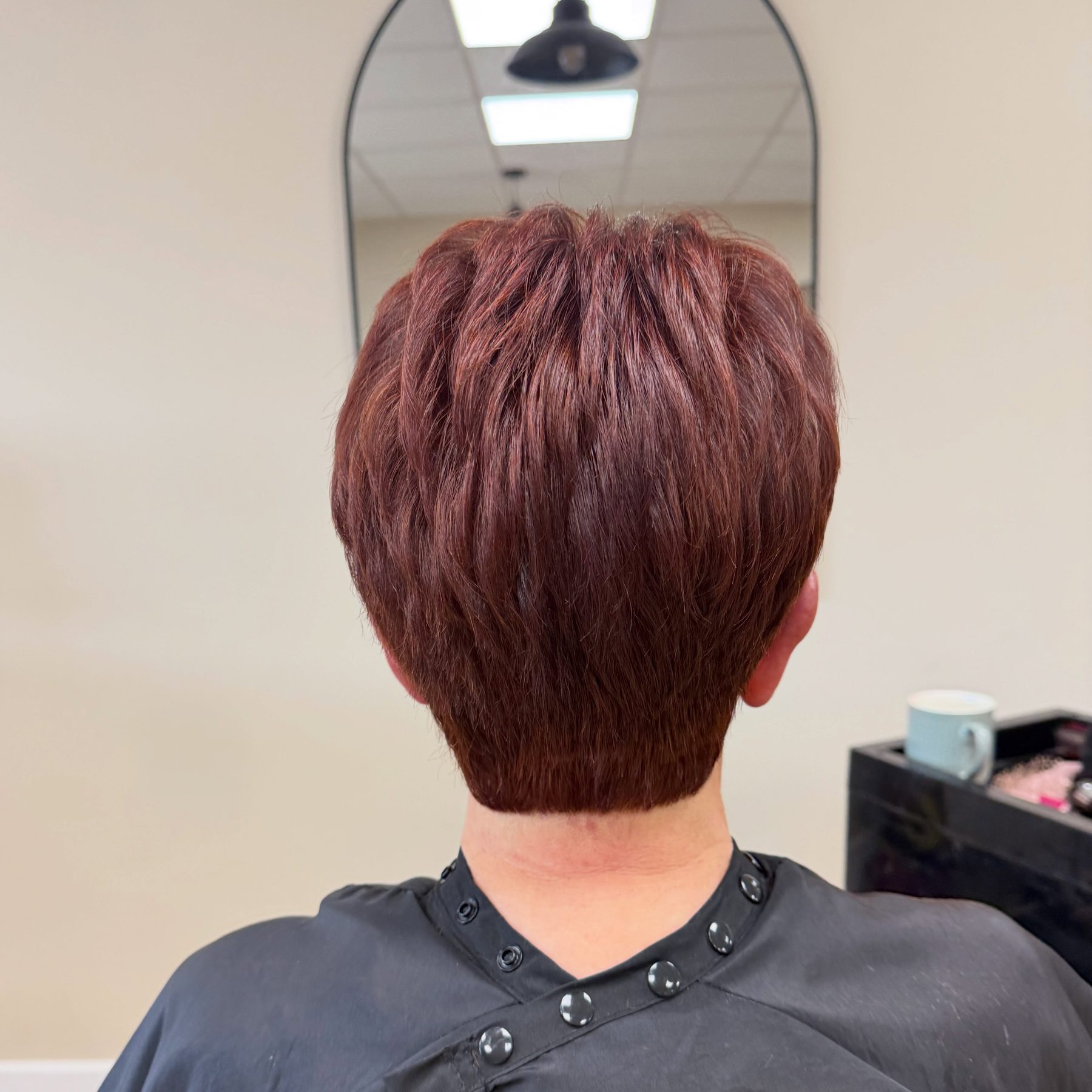 Short, layered crop in a rich deep red, seen from behind
