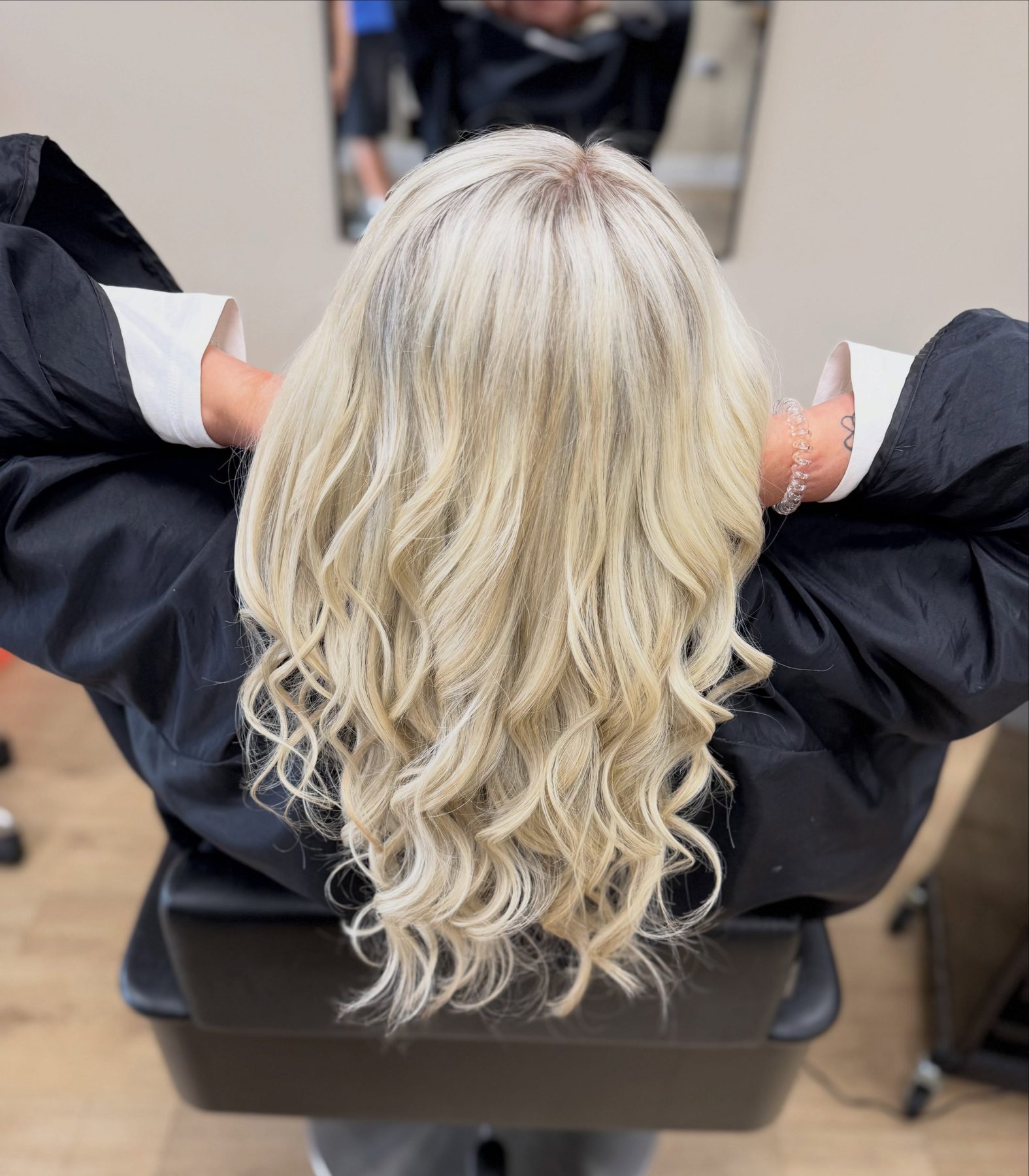 Long, curled buttery blonde hair for a bride to be, seen from behind